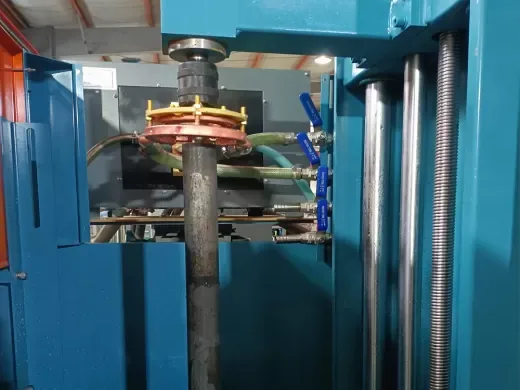 Induction hardening machine with a shaft passing through the heating coil